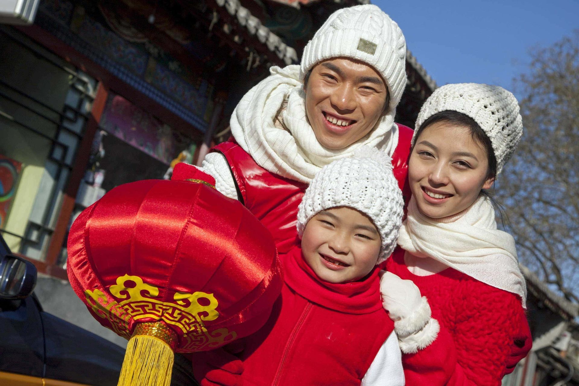 A family is posing for a picture while holding a red lantern.