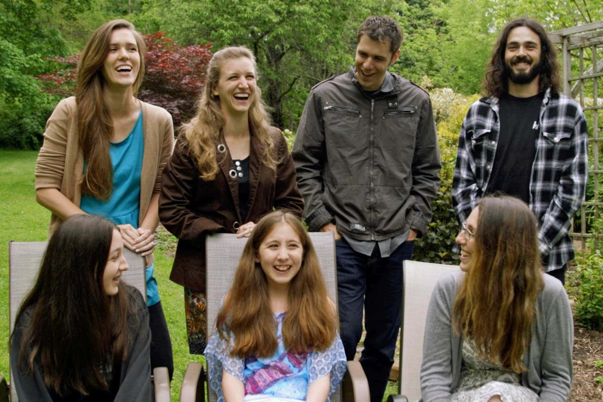 A group of people are posing for a picture in a park.