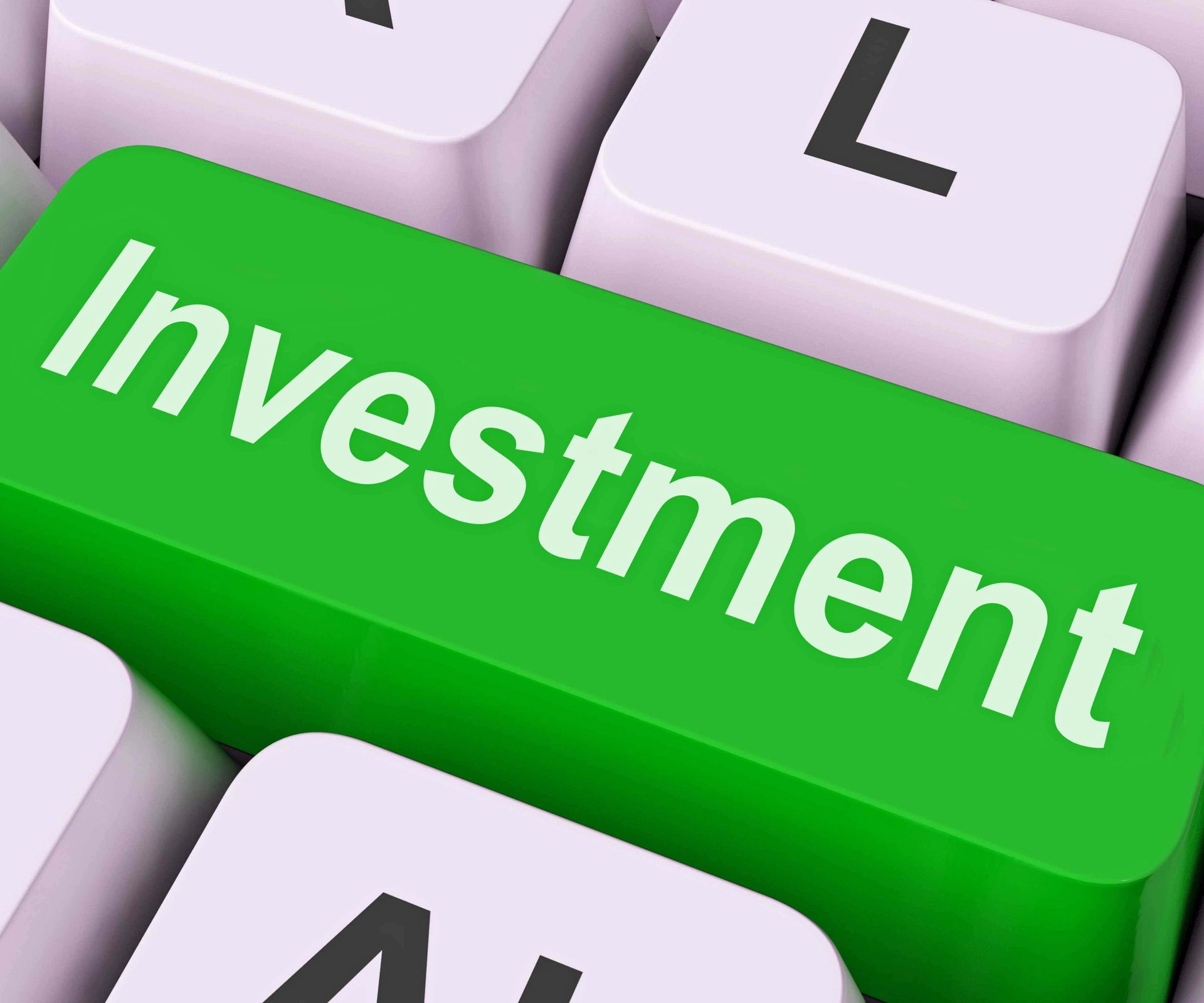 A green key on a keyboard that says investment