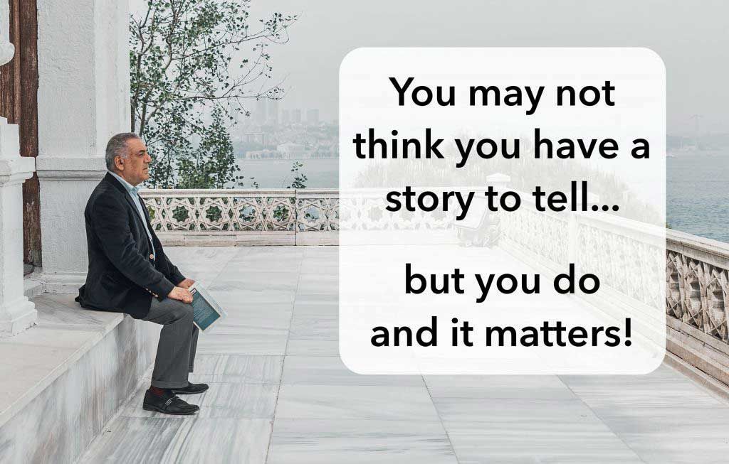 A man is sitting on a ledge with a quote.