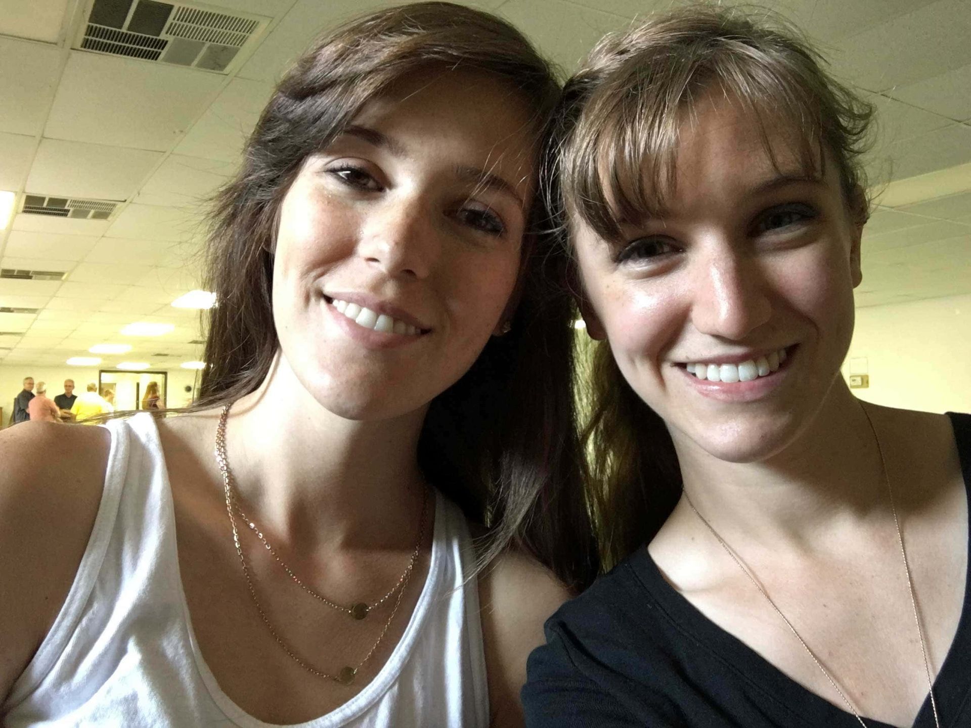 Two women are posing for a picture and smiling for the camera