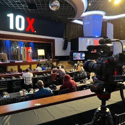 A camera is sitting in front of a sign that says 10x