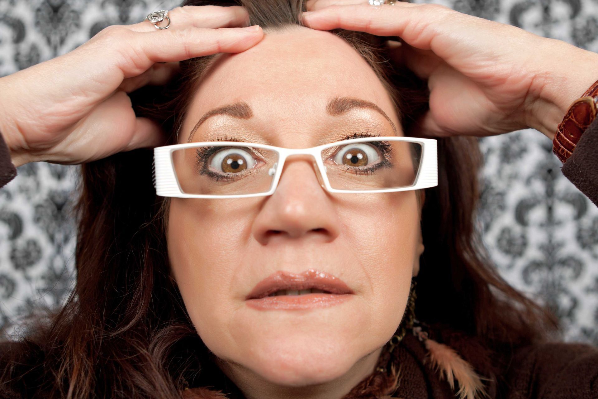 A woman wearing glasses is making a funny face