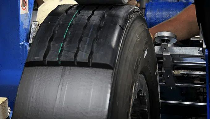 A person is working on a tire in a factory.