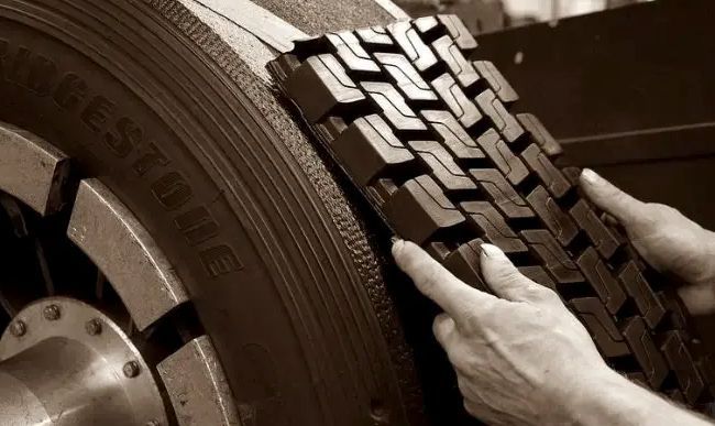 A person is holding a tire that says bridgestone on it