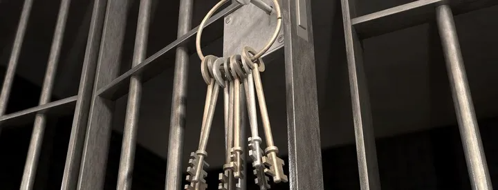 Keys hanging on a metal prison cell door.
