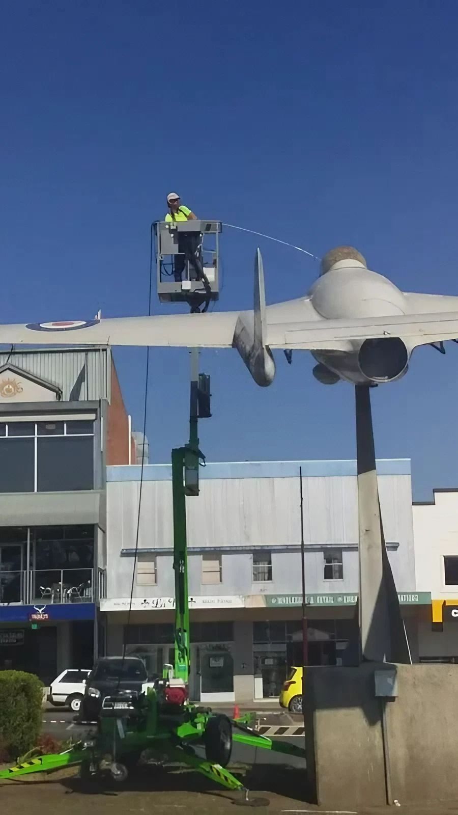 Man on Hydraulic Lift Cleaning a Metal Sculpture — Complete Pressure Cleaning in Glen Port Macquarie, NSW