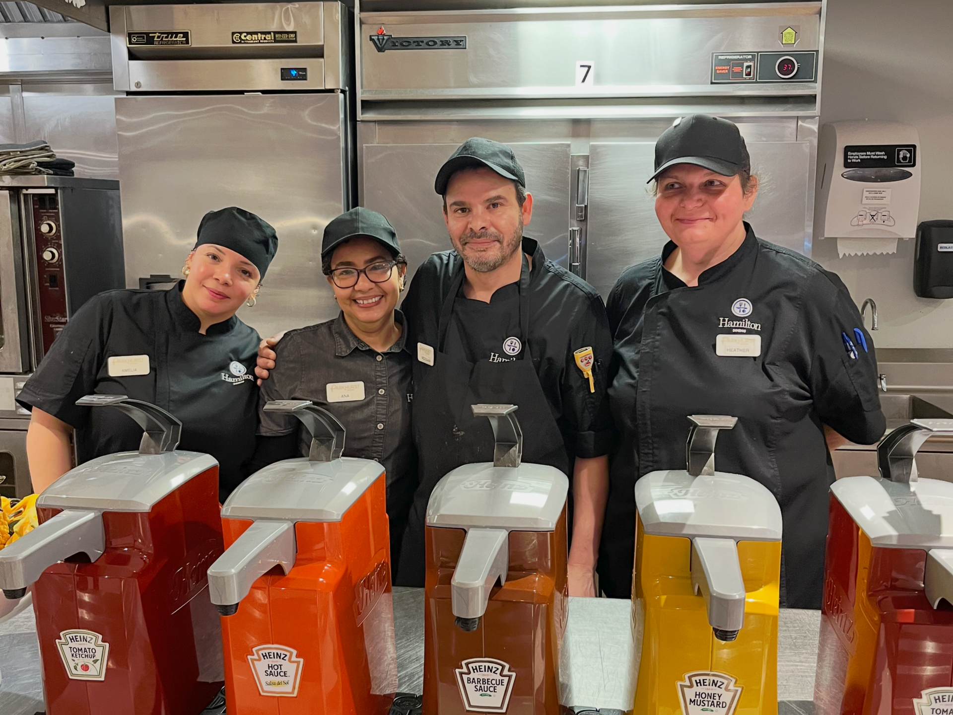 A group of chefs are posing for a picture in a kitchen.