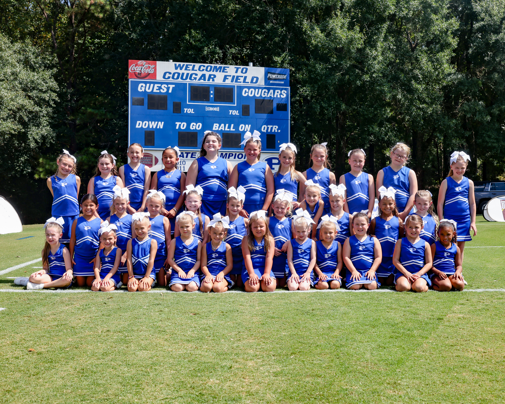 A group of cheerleaders are posing for a team photo.
