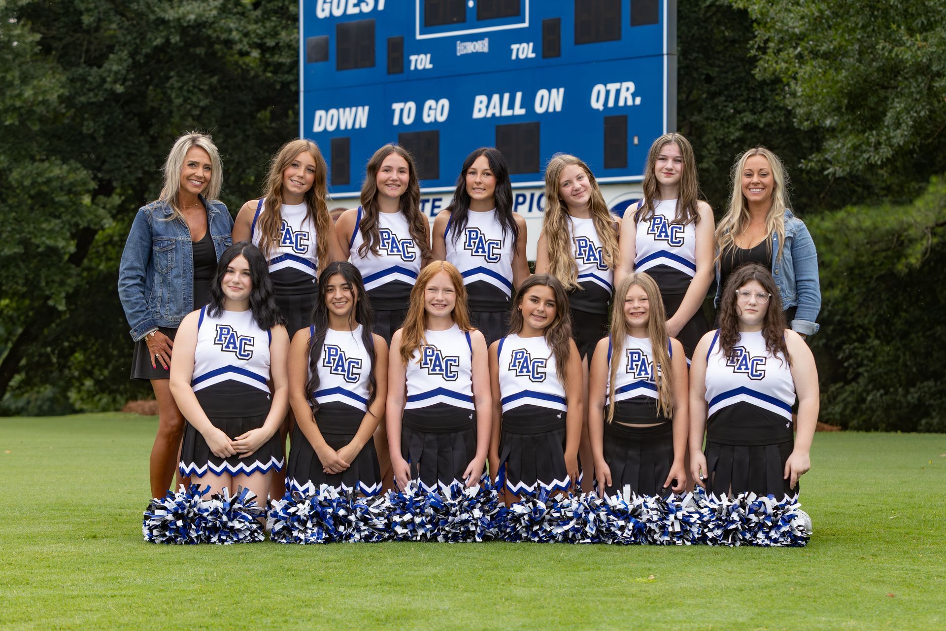 A group of cheerleaders are posing for a picture.