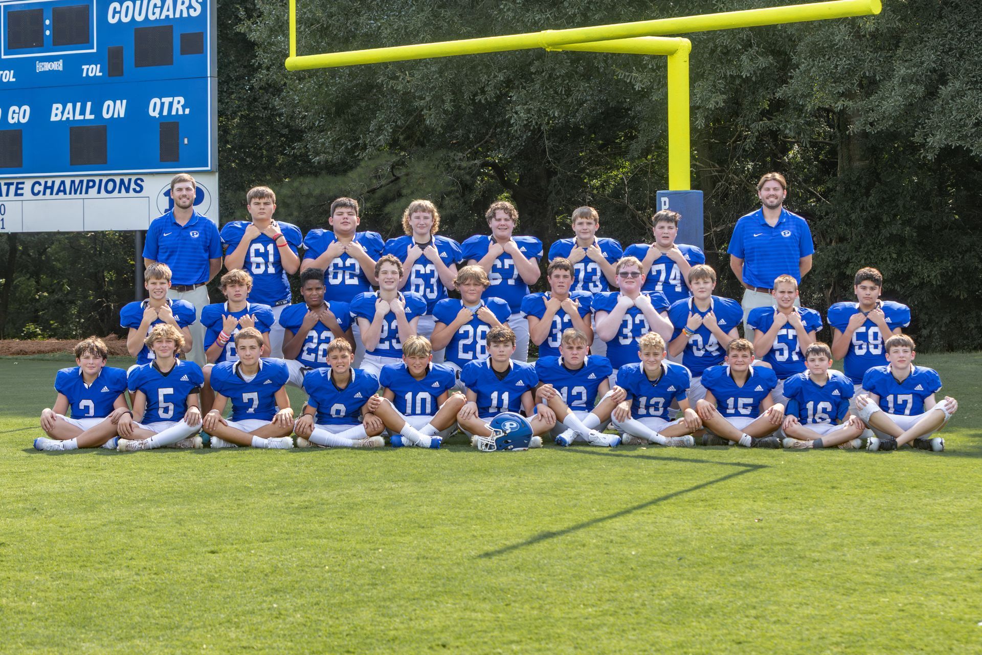 A group of young boys are posing for a football team photo.