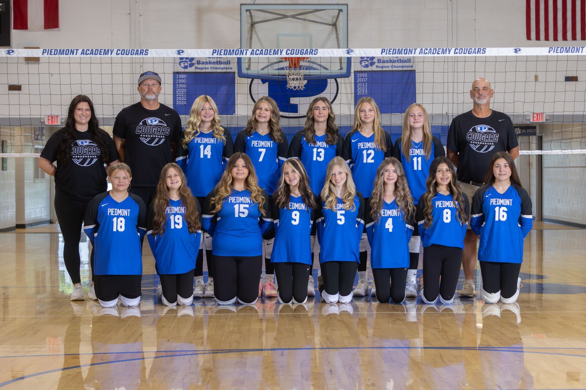 A group of volleyball players are posing for a team photo.