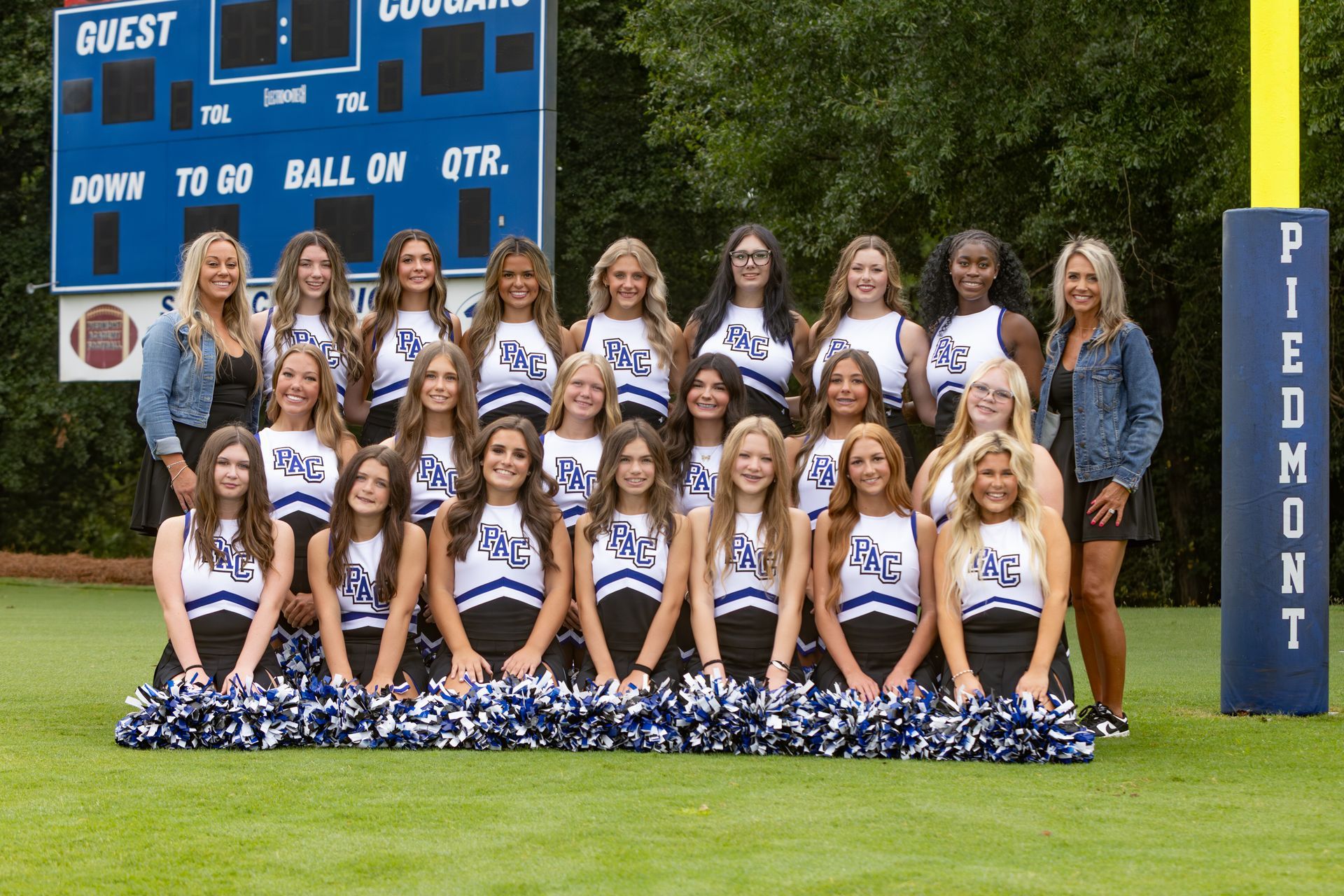 A group of cheerleaders are posing for a picture.
