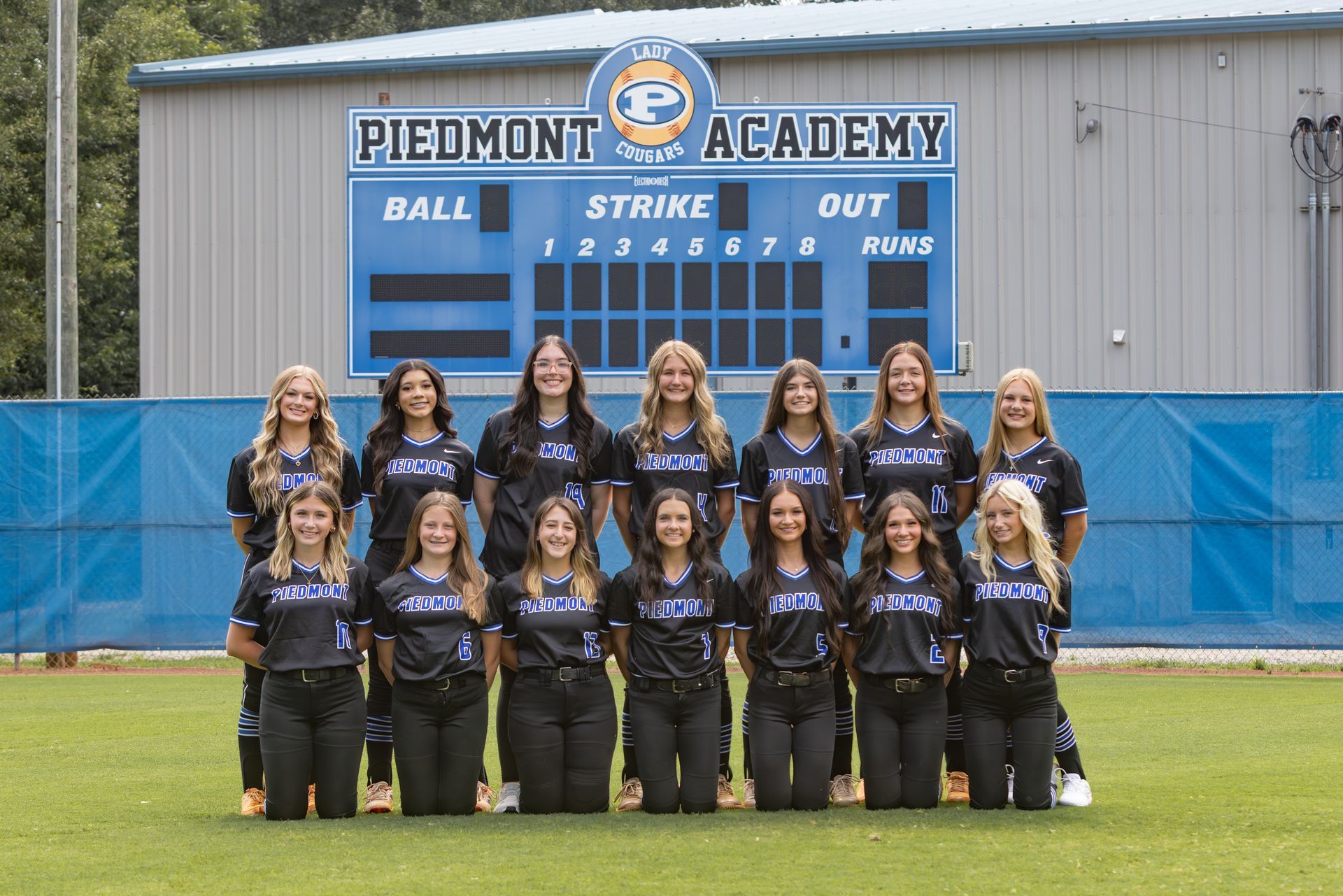 The piedmont softball team is posing for a team photo.