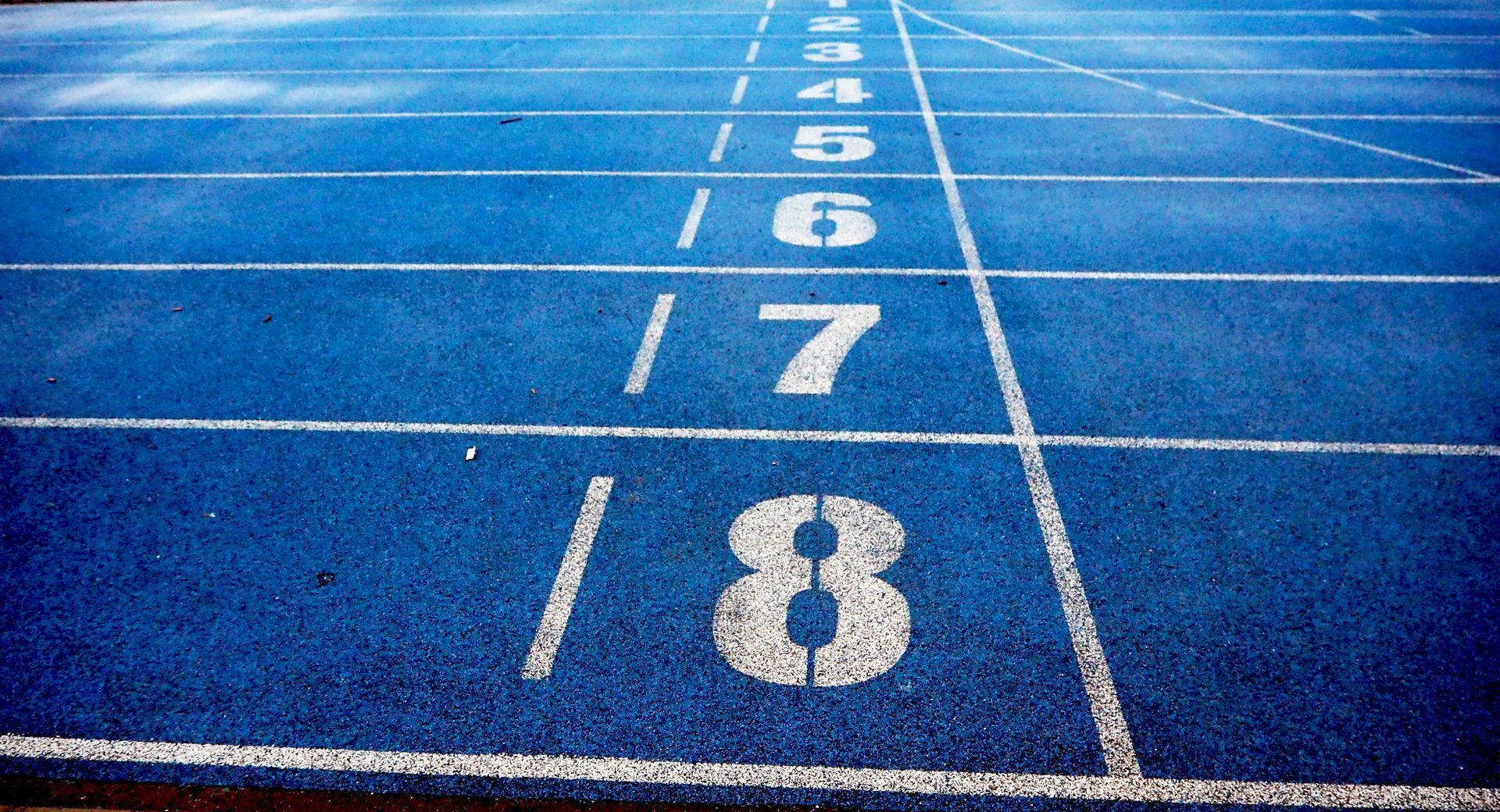 A blue track with white lines and numbers painted on it.
