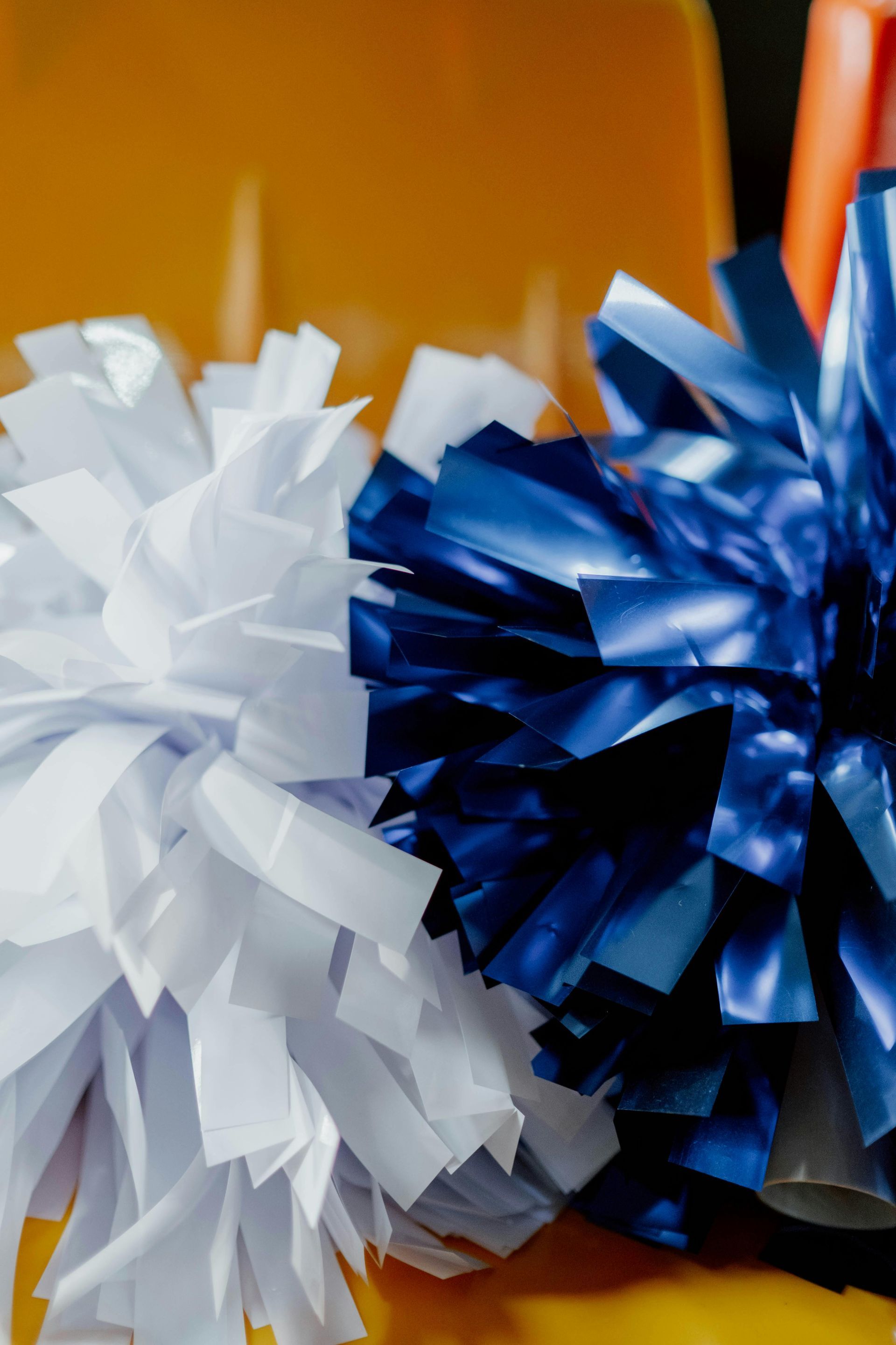 Blue and white pom poms on a yellow chair