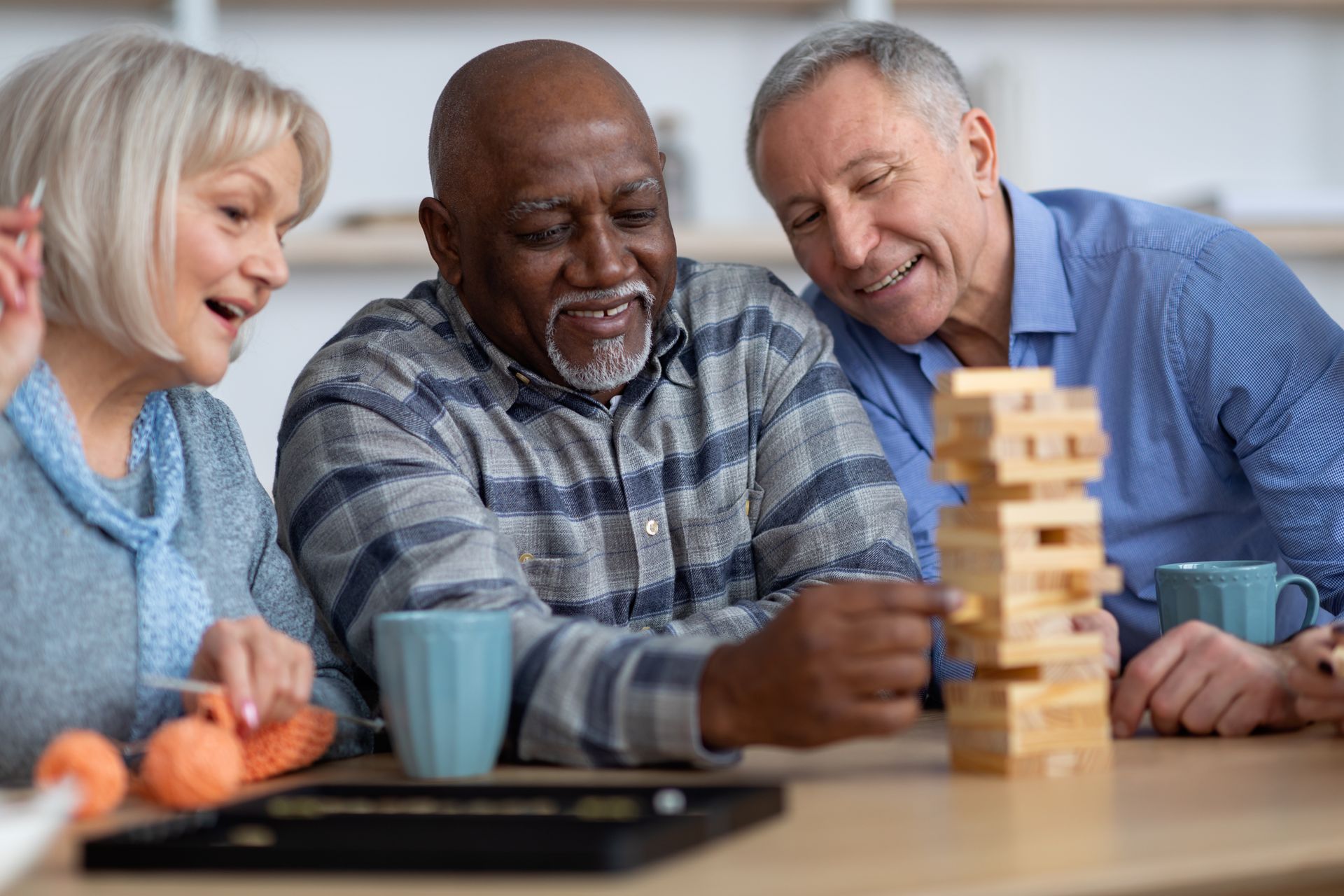 A group of elderly people are playing a game of jenga.