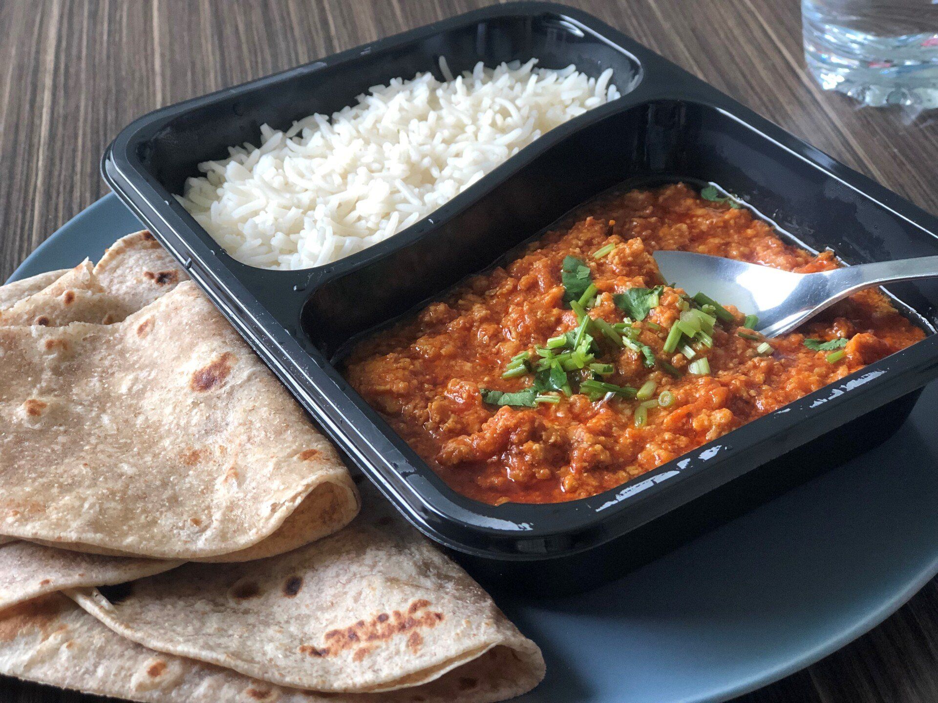 A tray of food with rice and a tortilla on a plate.