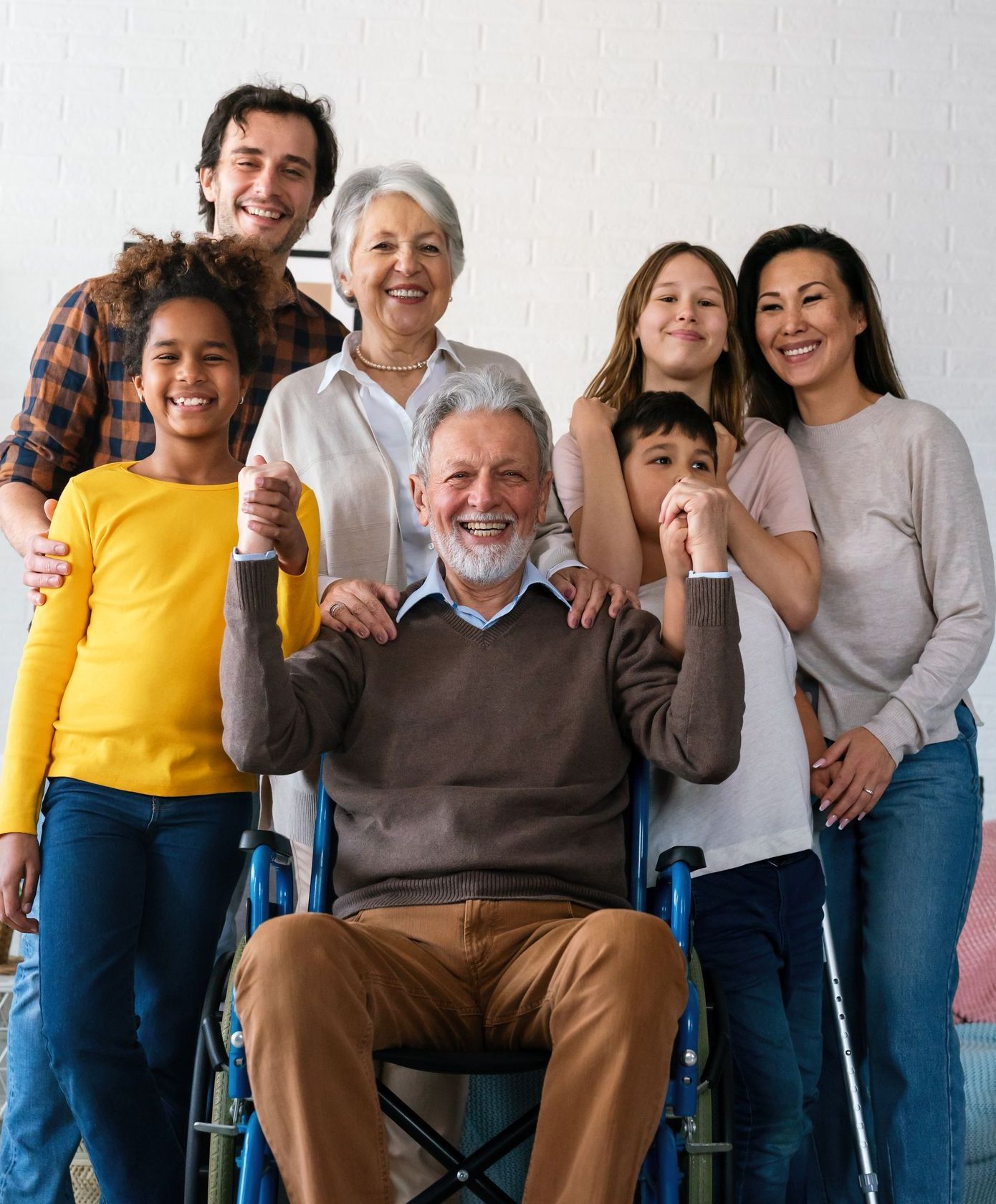 A man in a wheelchair is posing for a picture with his family.