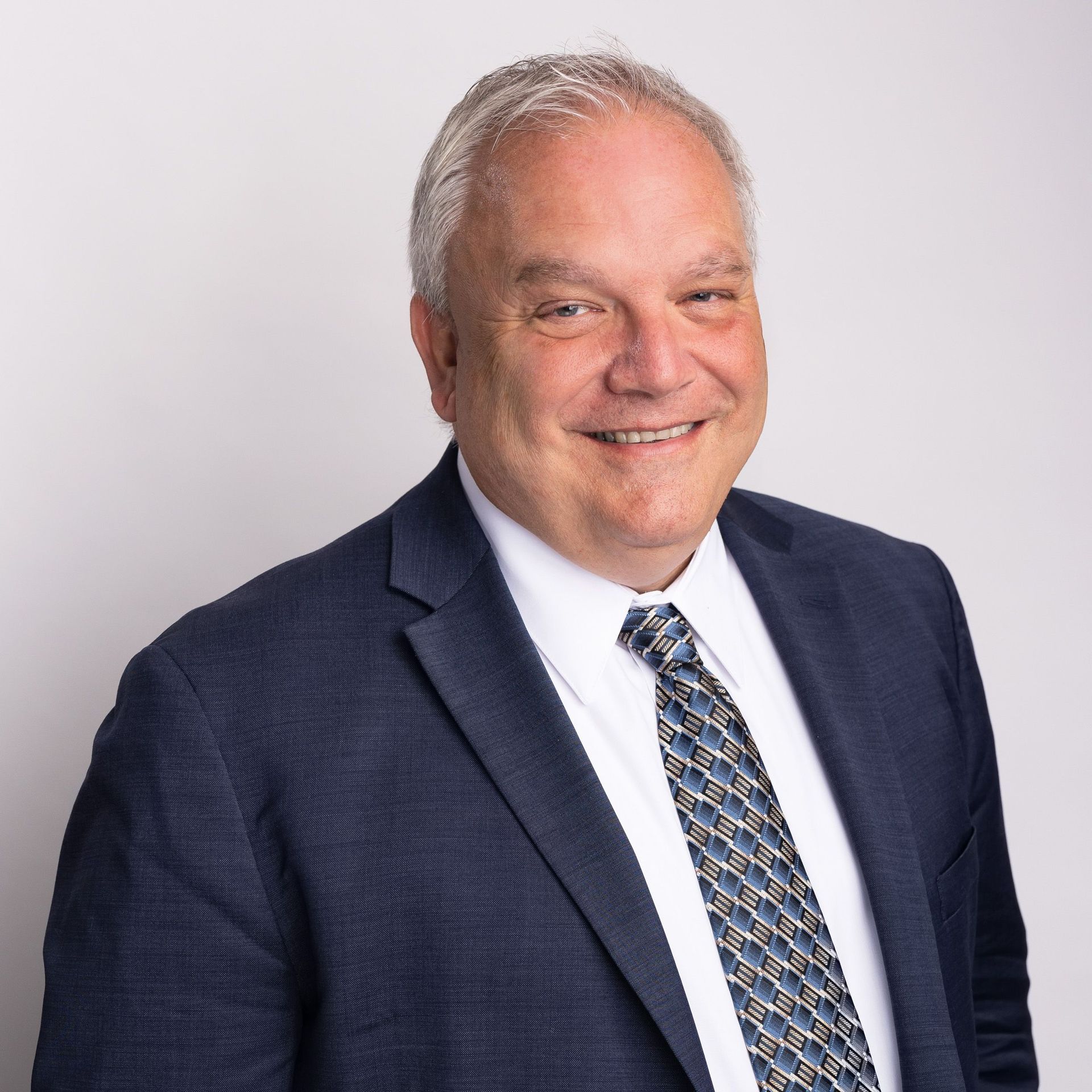 A man in a suit and tie is smiling for the camera.