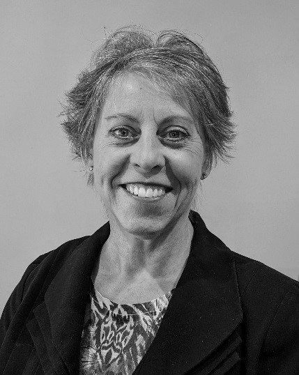 A woman is smiling in a black and white photo.
