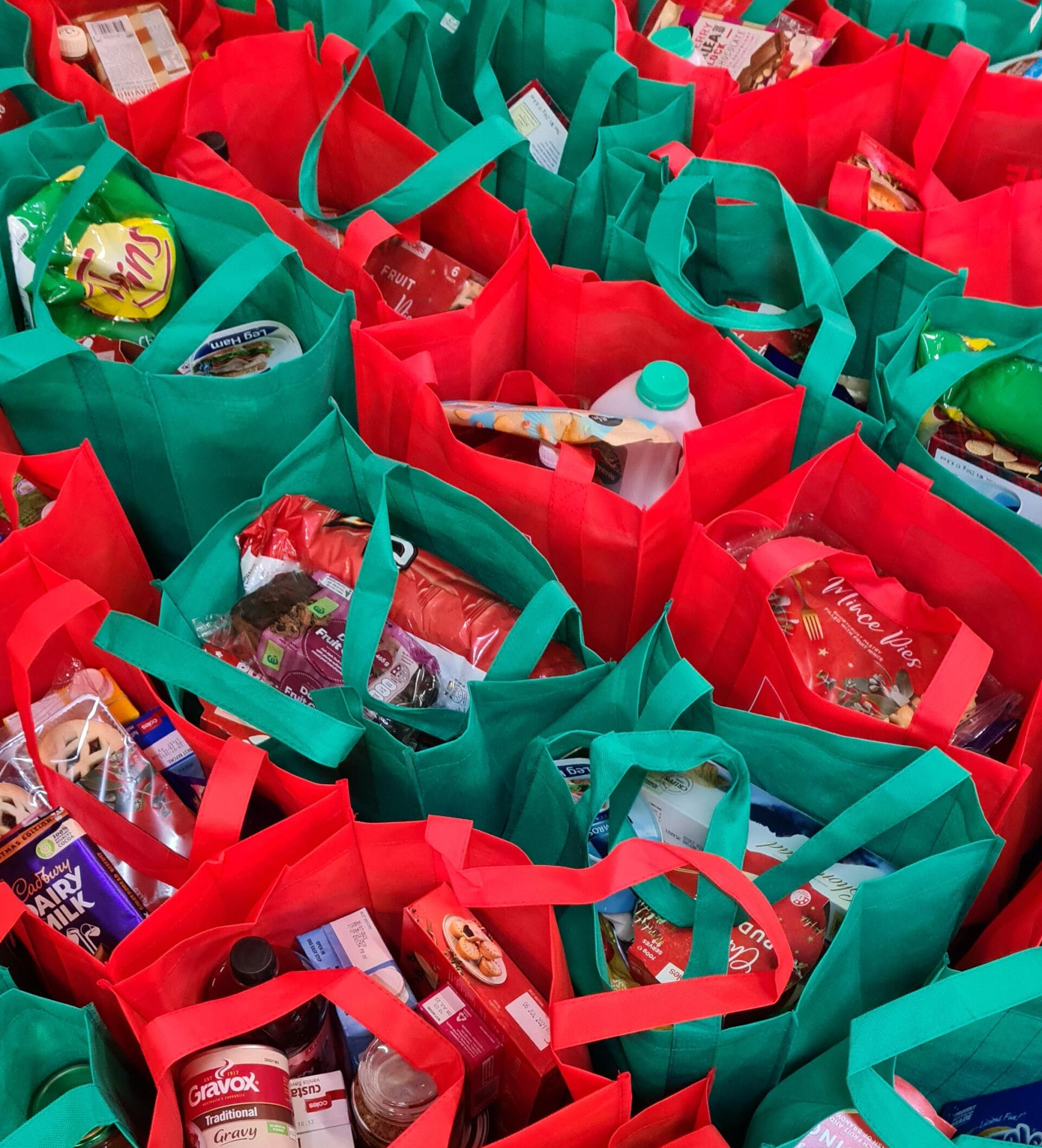 A bunch of red and green bags filled with food
