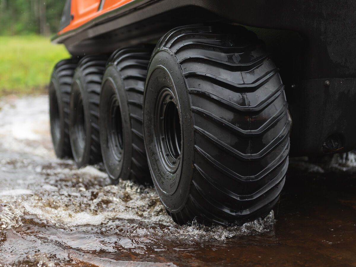 a close up of a ATV's tires on a muddy road