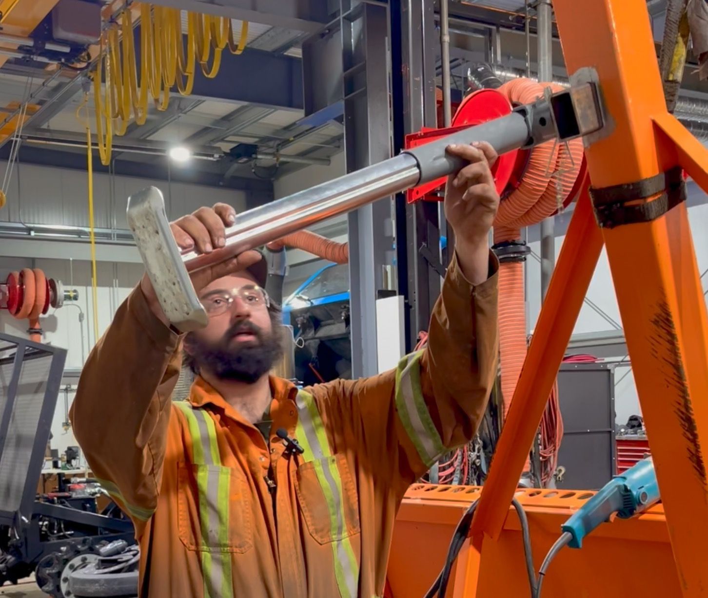 Damon sanding paint from the Fat Truck trailer so he can weld on a tongue-jack.