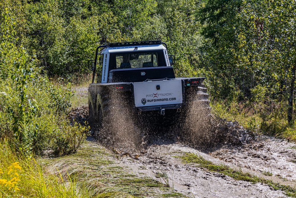 Fat Truck industrial vehicle safety and effortlessly driving through mud and water.