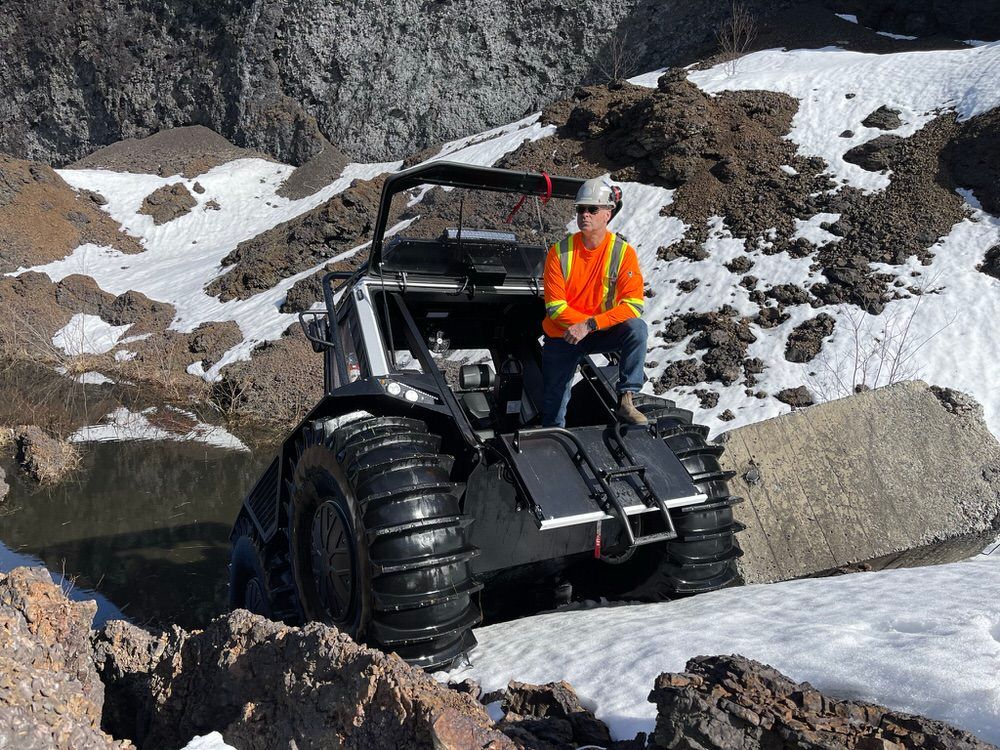 Fat Truck parked on a steep incline of rock and snow with its front hatch opened.