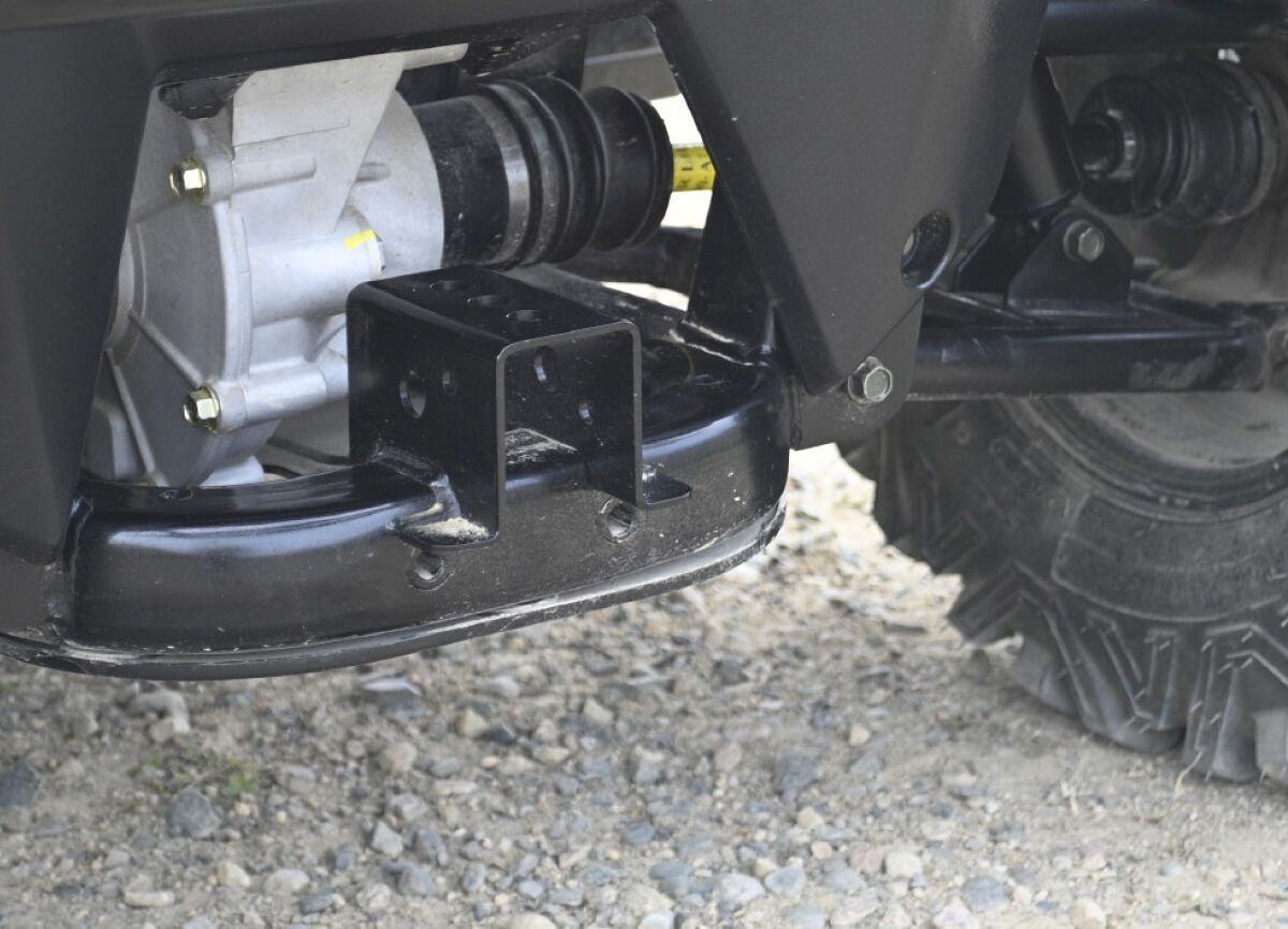 a close up of a vehicle 's rear axle with a warning label on it