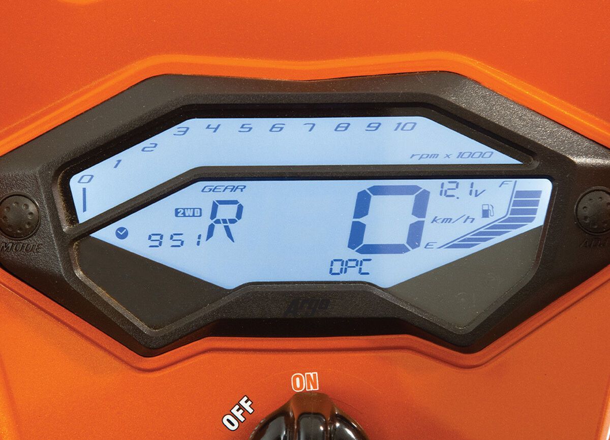 A digital instrument gauge on an orange ATV.