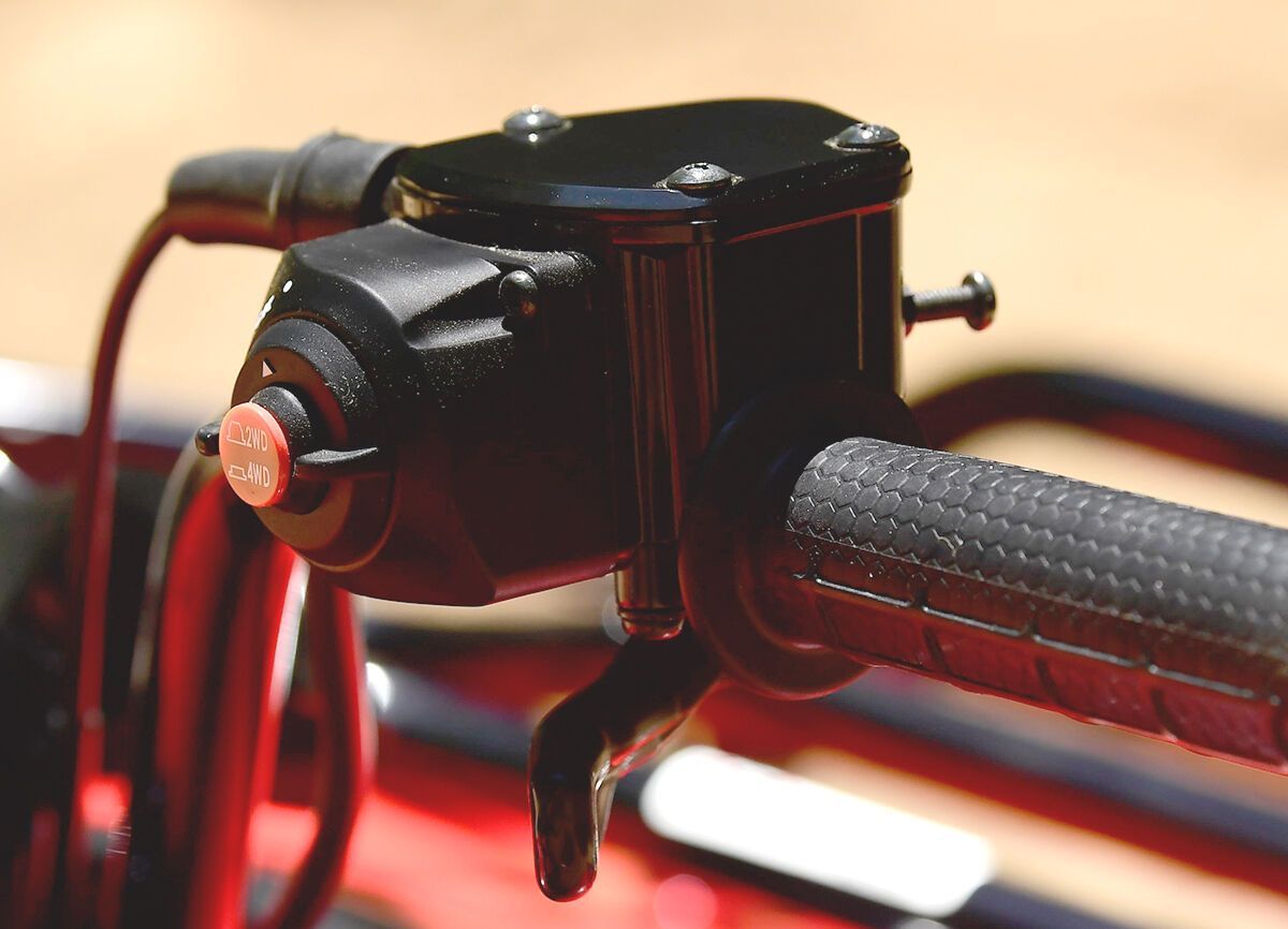 A push button mounted on the handlebars of an ATV.