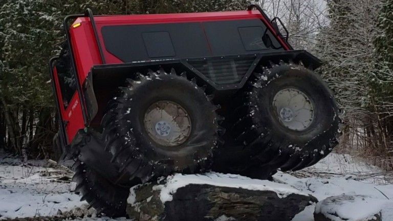 Fat Truck at a severe tilt going over a large boulder.