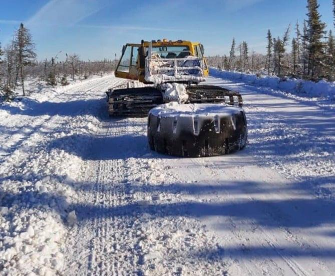 An example of an older, less effective method of smoothing some bumps is to drag an old tire behind a snow groomer.