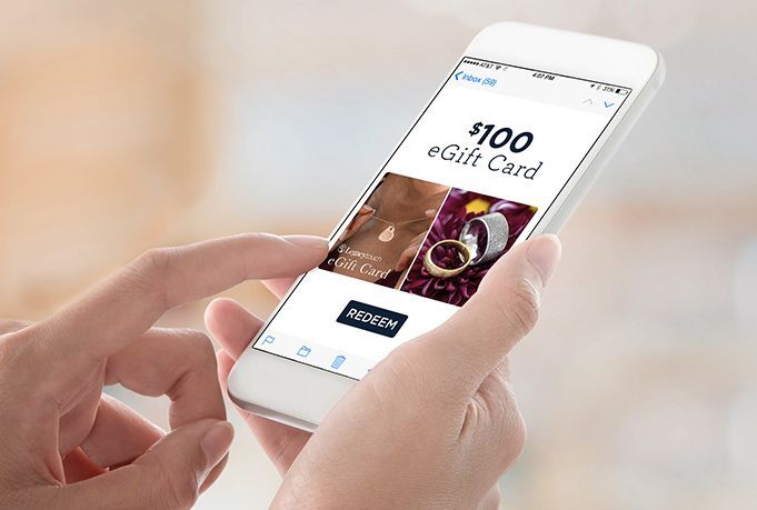 Hands holding a smartphone displaying a shopping app on a white screen