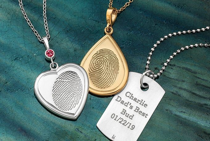Three personalized engraved pendants on a teal background: silver heart, gold teardrop, and dog tag.