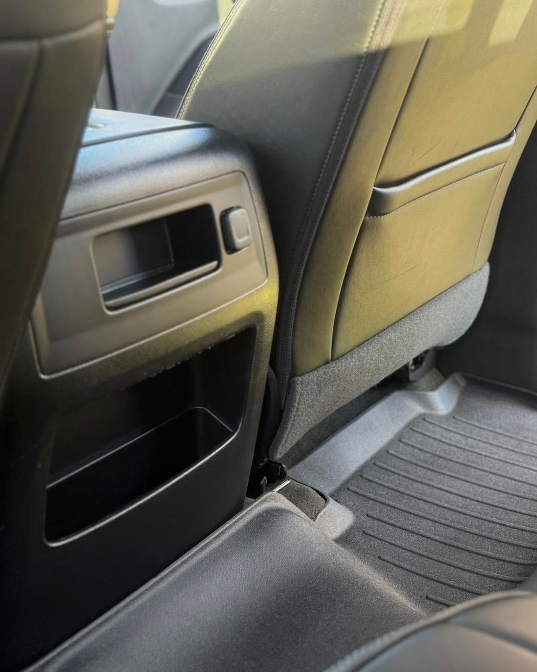 Car interior showing rear seat vents and storage pocket behind the front seats