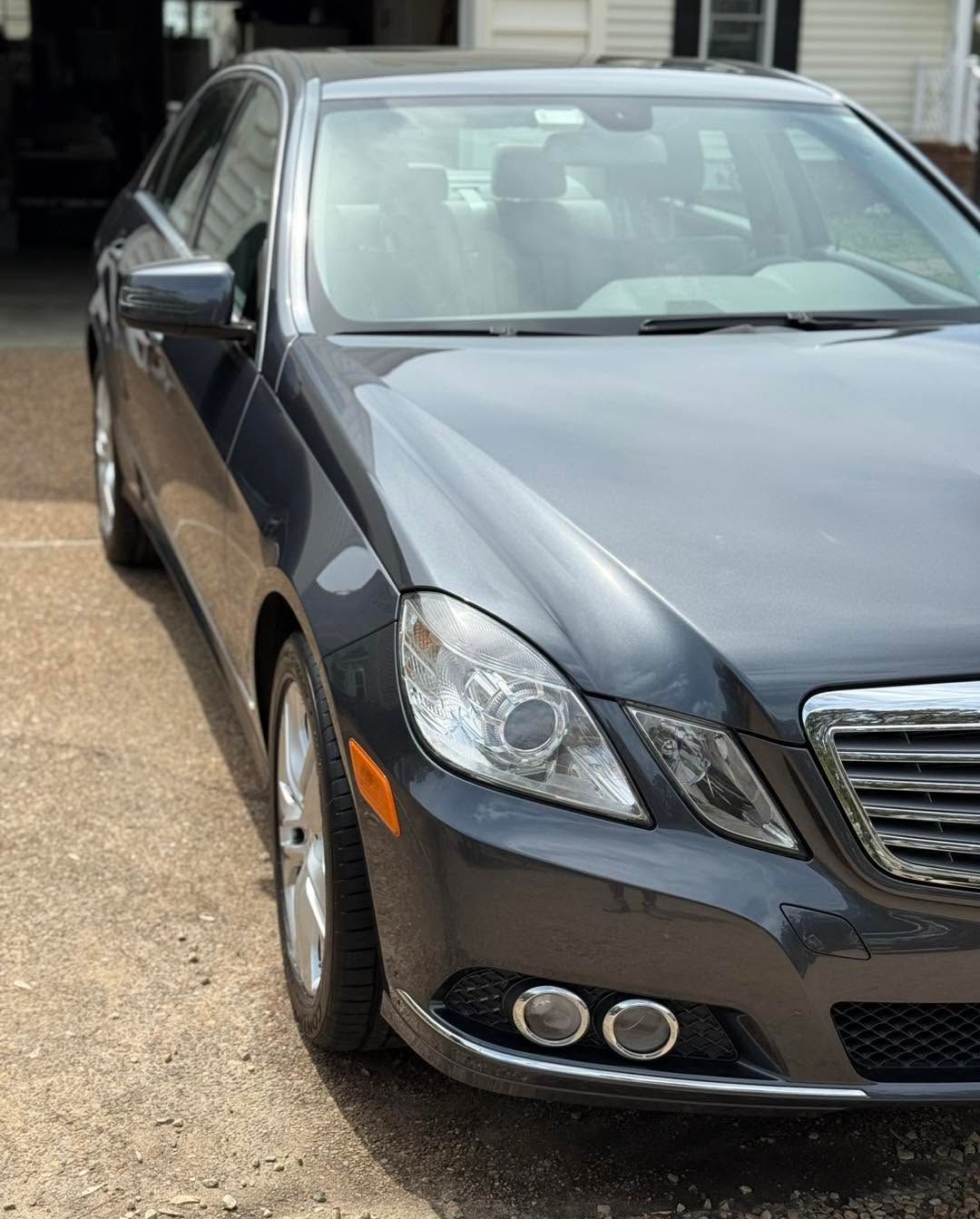 Dark gray sedan parked outside a building, front-left view