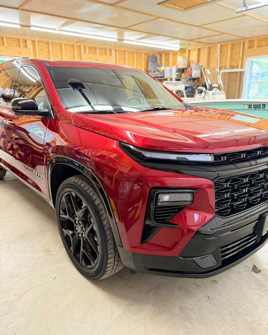 Red SUV in a garage, shown from the front-left side.