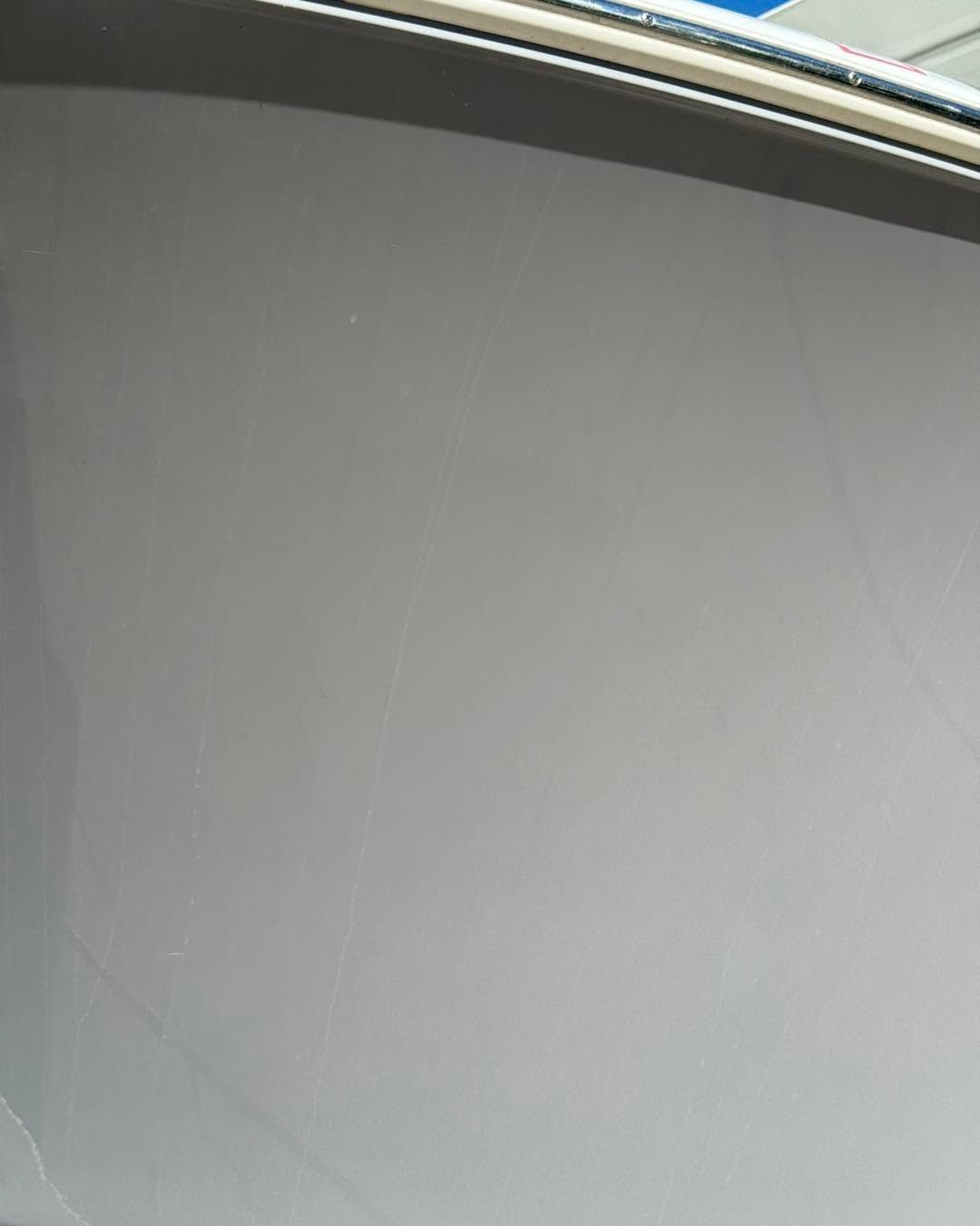 Gray textured surface with a curved metal edge at the top left