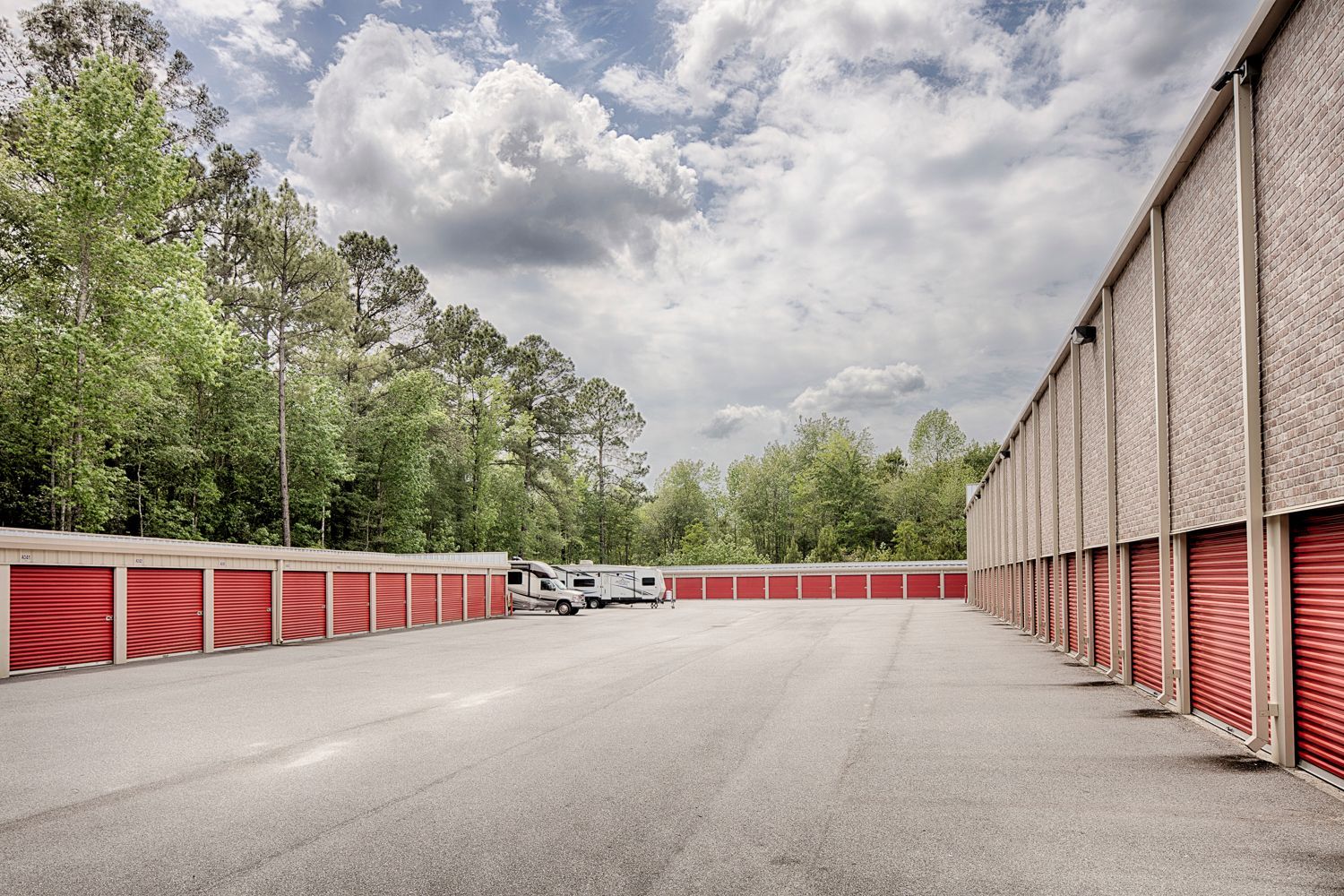 Drive-up storage units with red roll-up doors at Stop N Stor