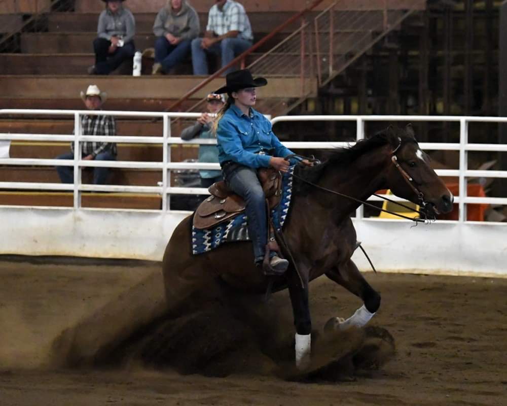 A woman in a cowboy hat is riding a horse