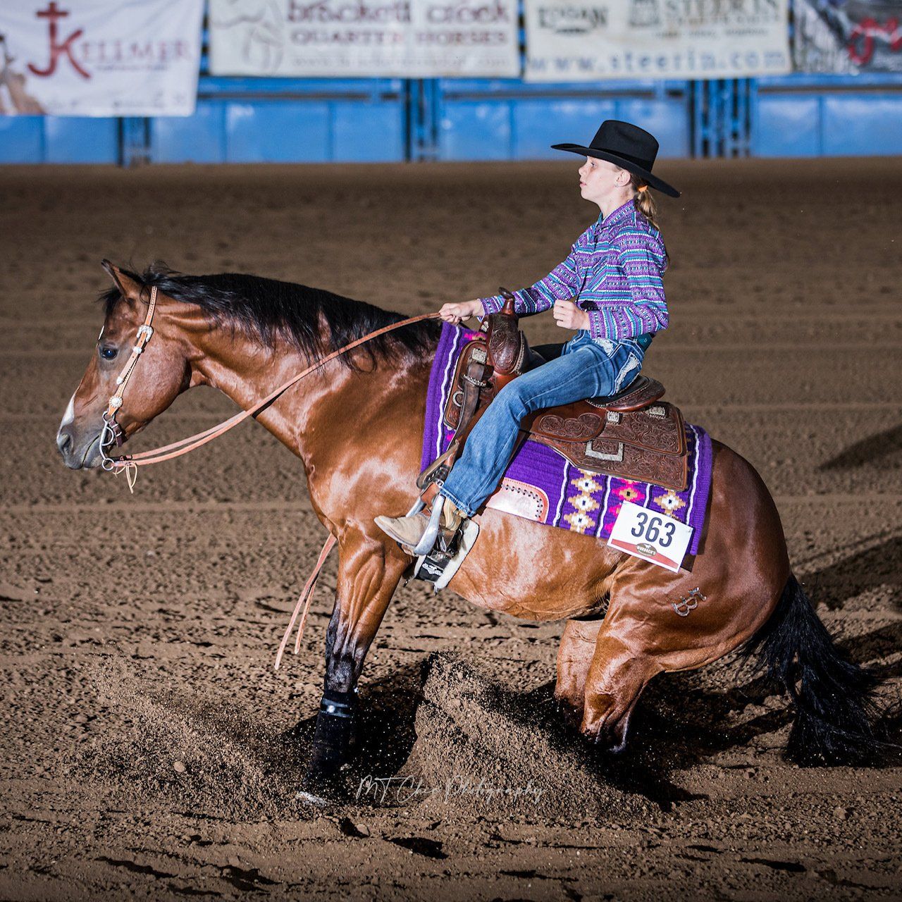 A woman is riding a horse with the number 363 on the back