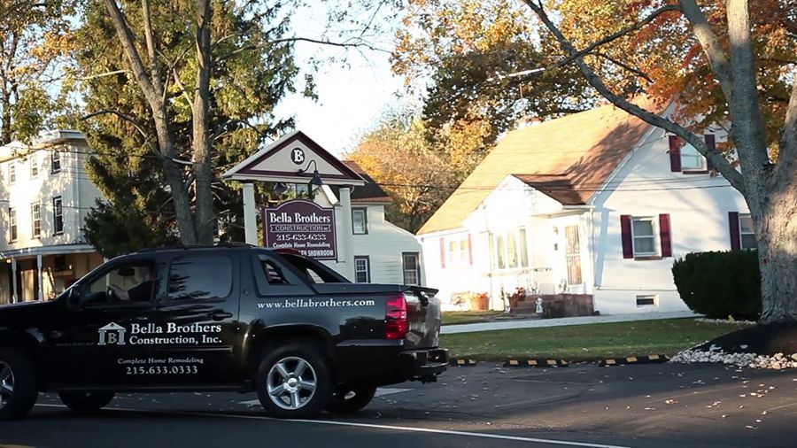 Black truck parked in front of a white building with a sign that reads