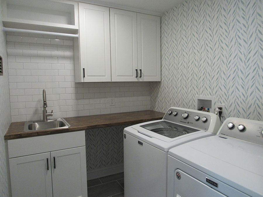 Modern bathroom with white vanity, wooden cabinet, and glass shower.