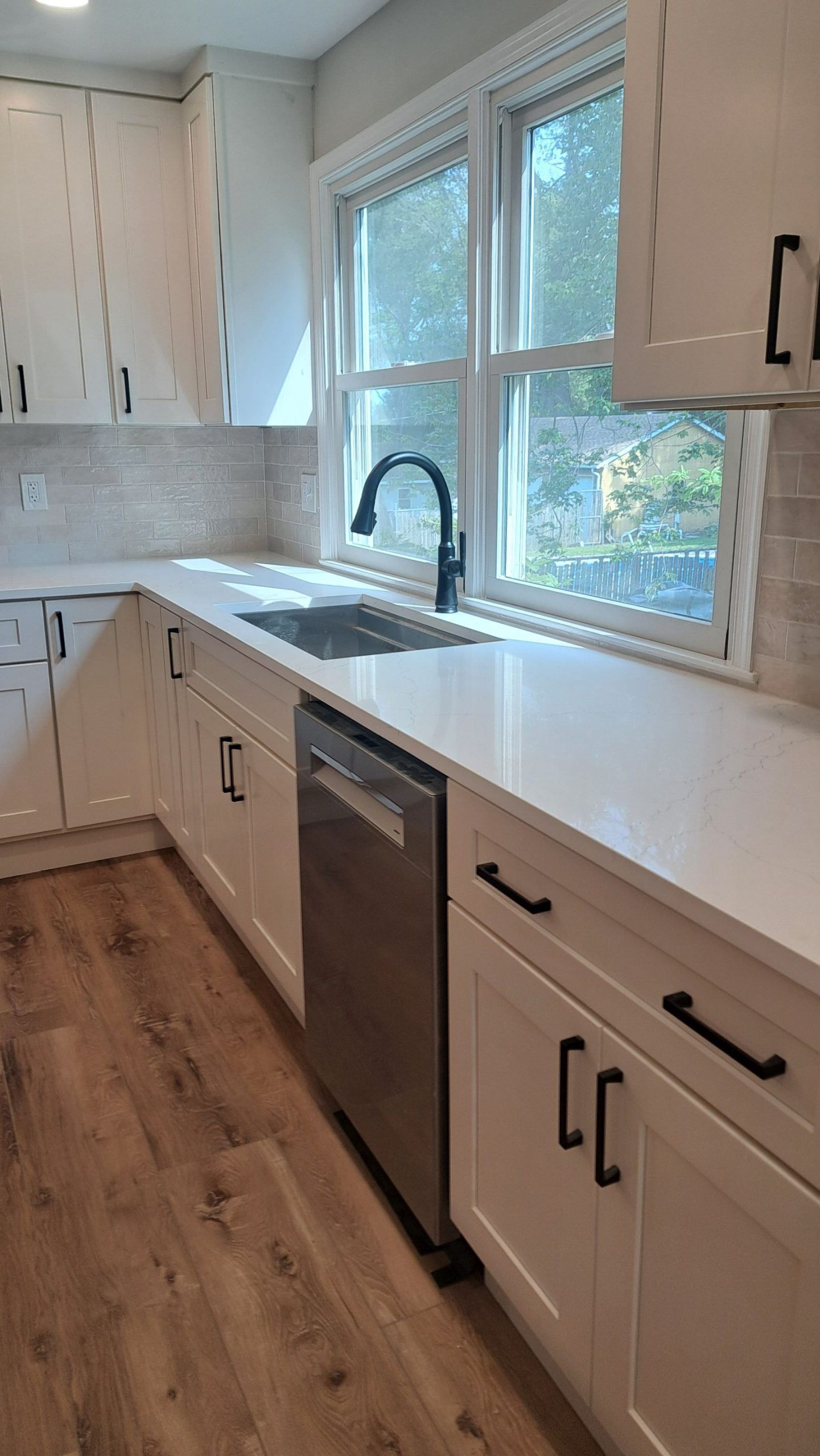 Kitchen with white and blue cabinets, island with stools, and gold accents.