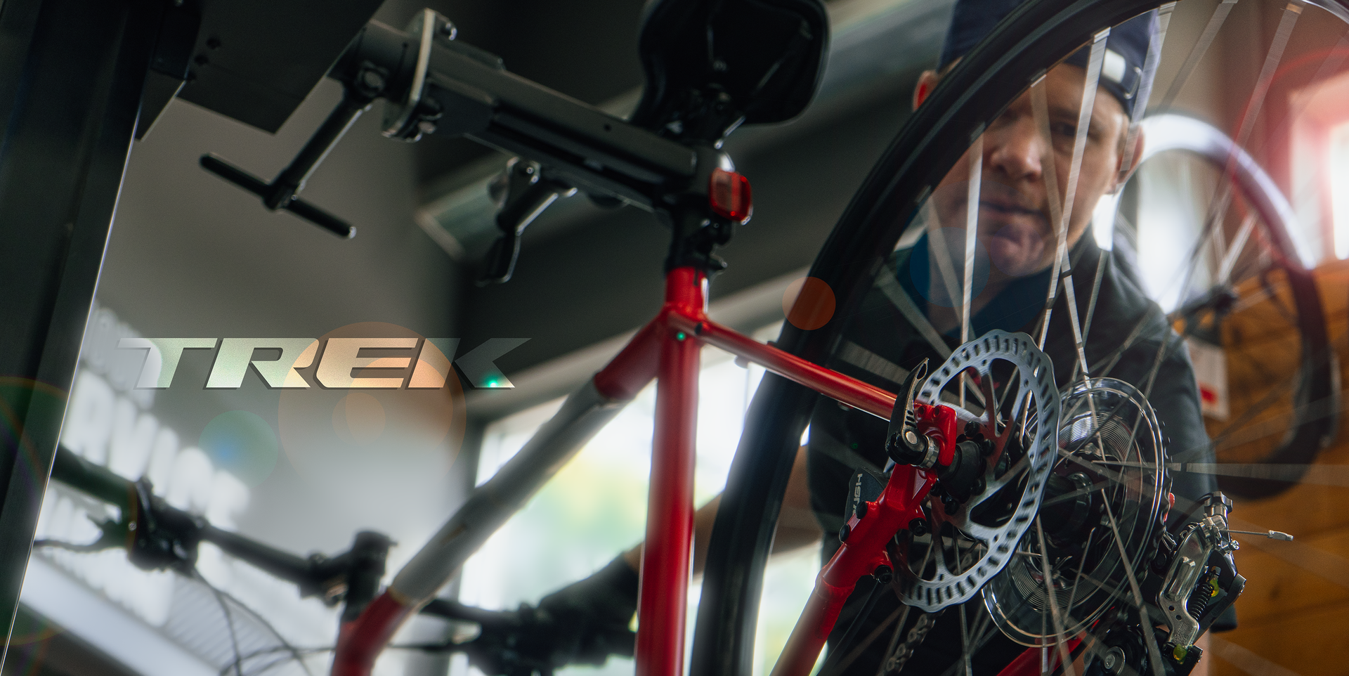 Red Trek bicycle with disc brake and rider reflected in a mirror indoors