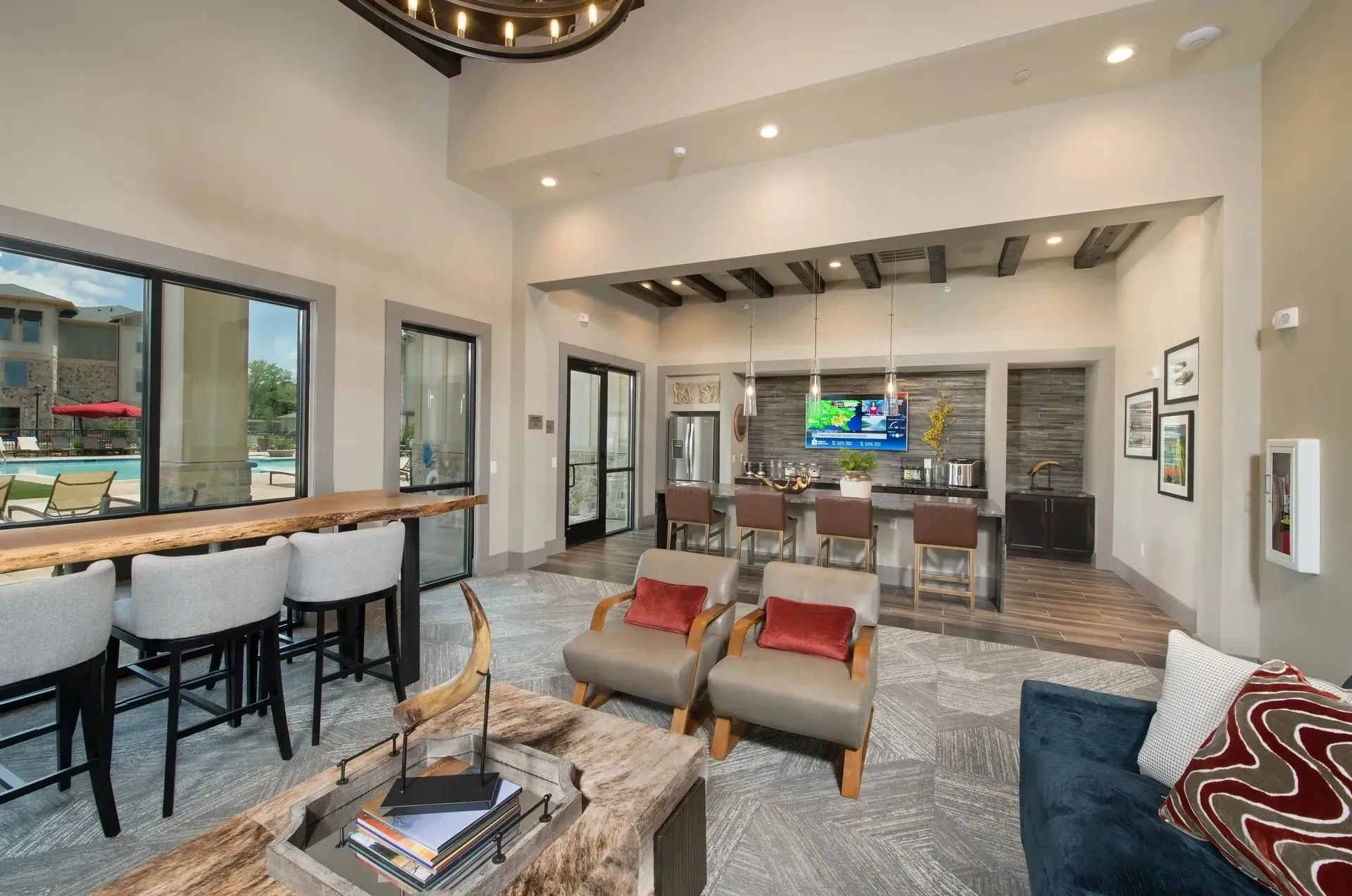 Interior view of a community lounge area featuring seating and a kitchenette.