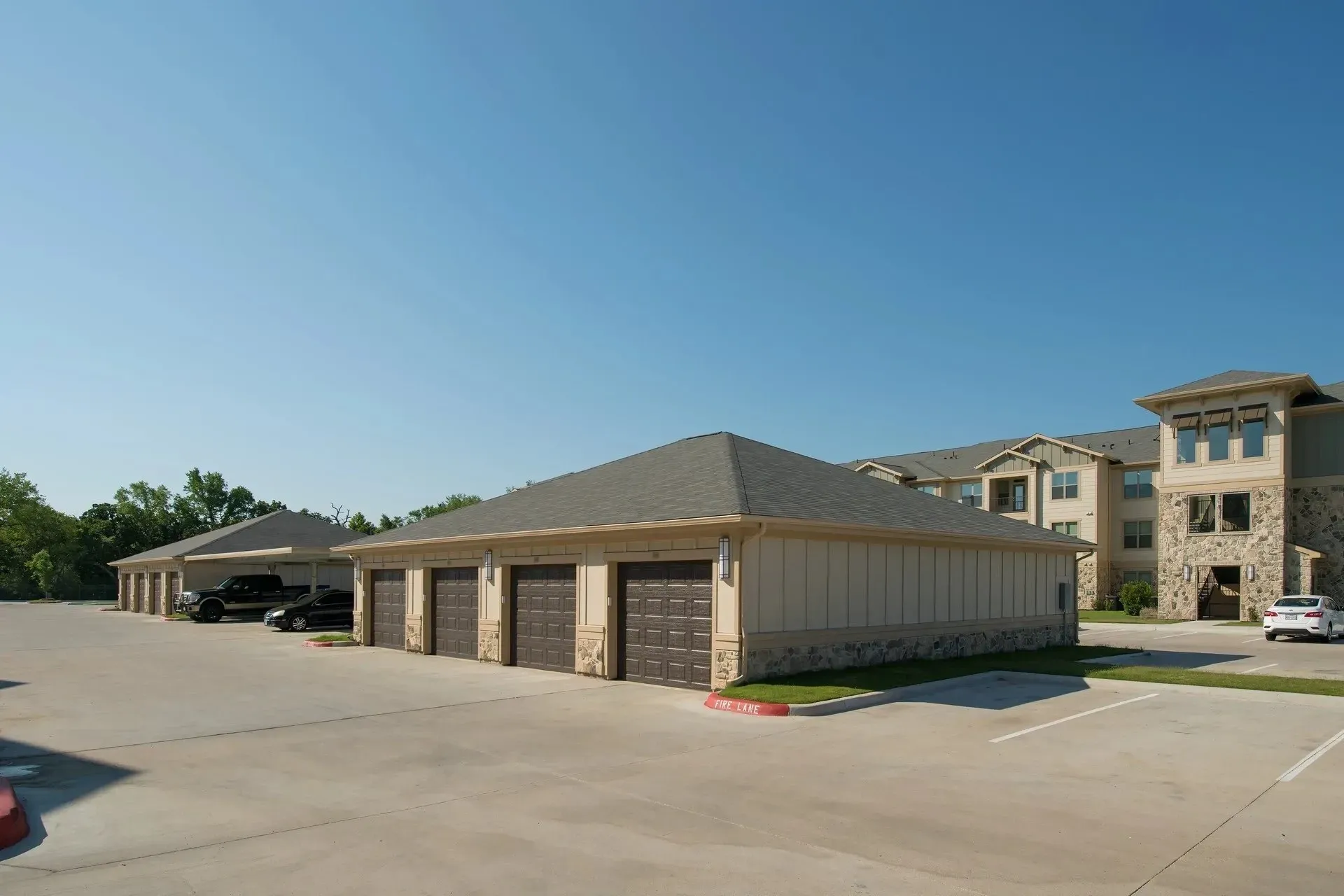 View of garages and apartment buildings under a clear blue sky